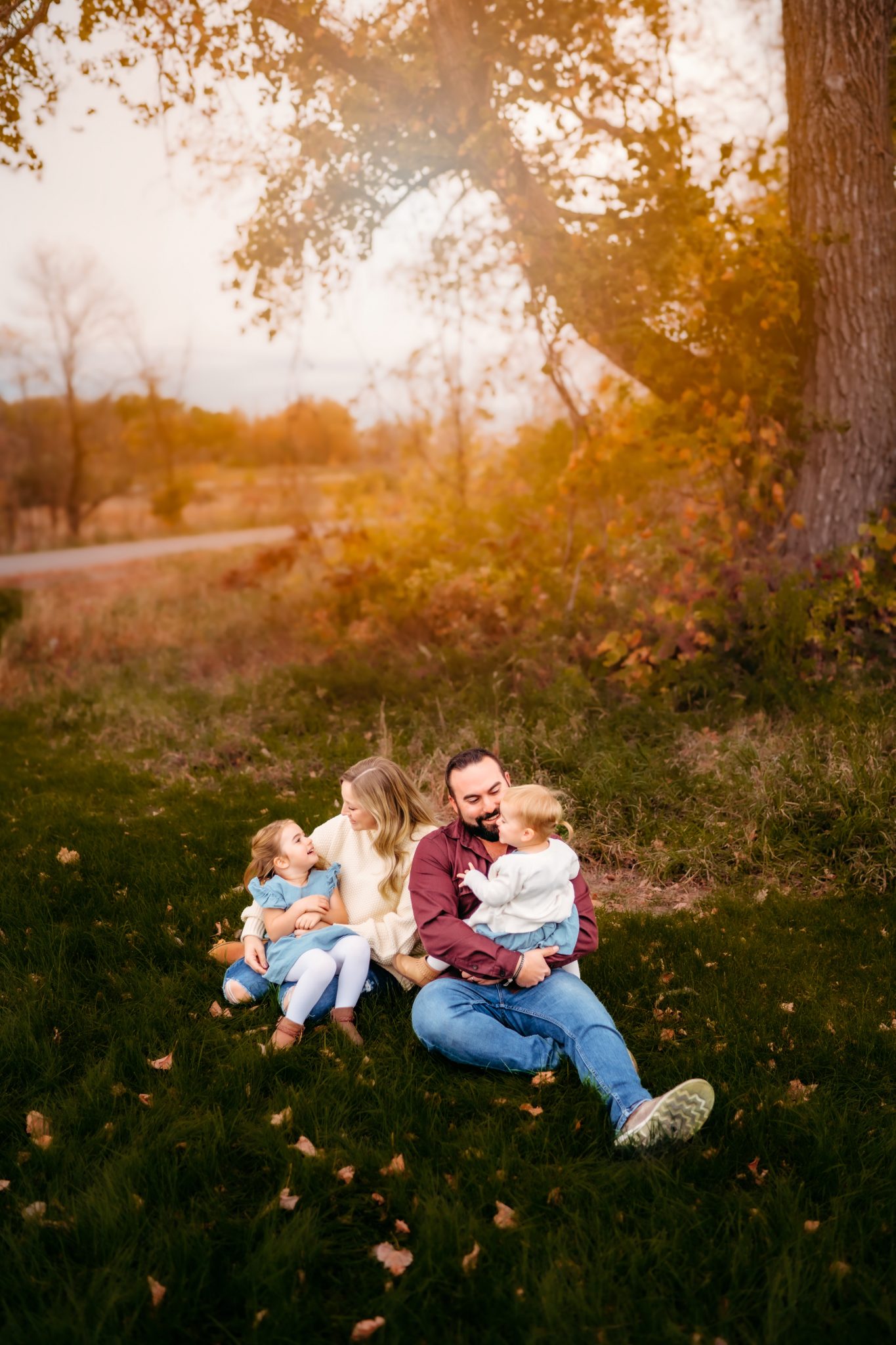 A family snuggles in grass on a golden fall evening near Alexandria MN